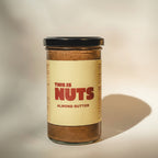 Jar of almond butter with a label reading 'This is Nuts' on a neutral background